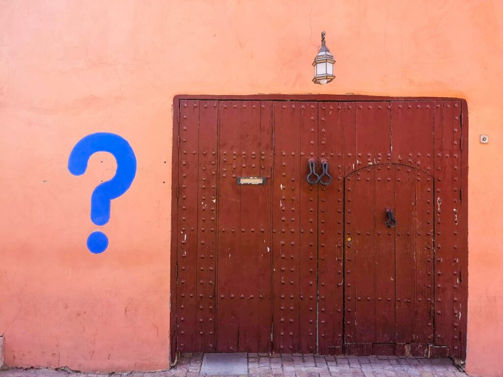 Blue Question Mark near brown wooden door